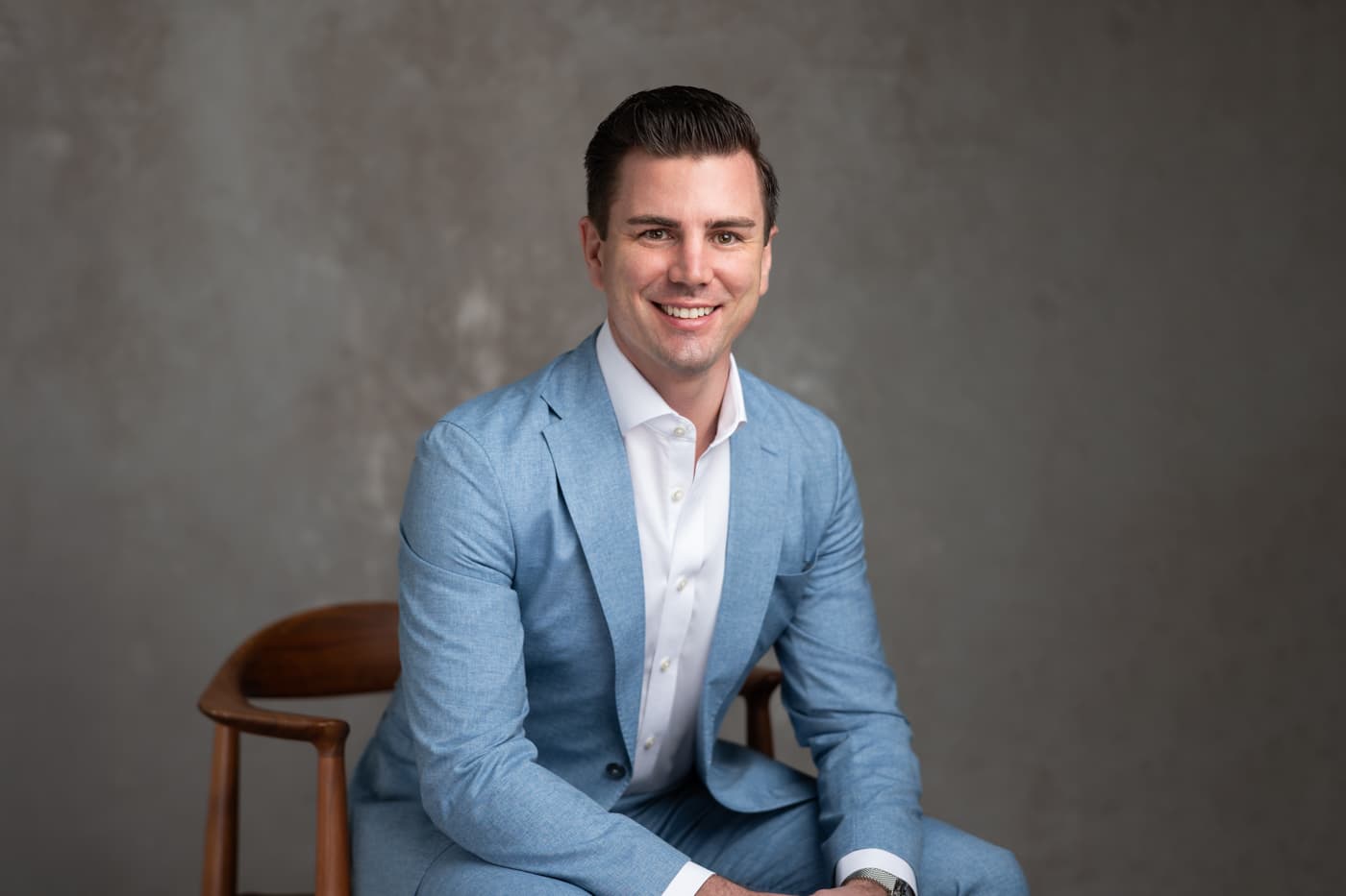 Dr James Doherty seated in a light blue suit.